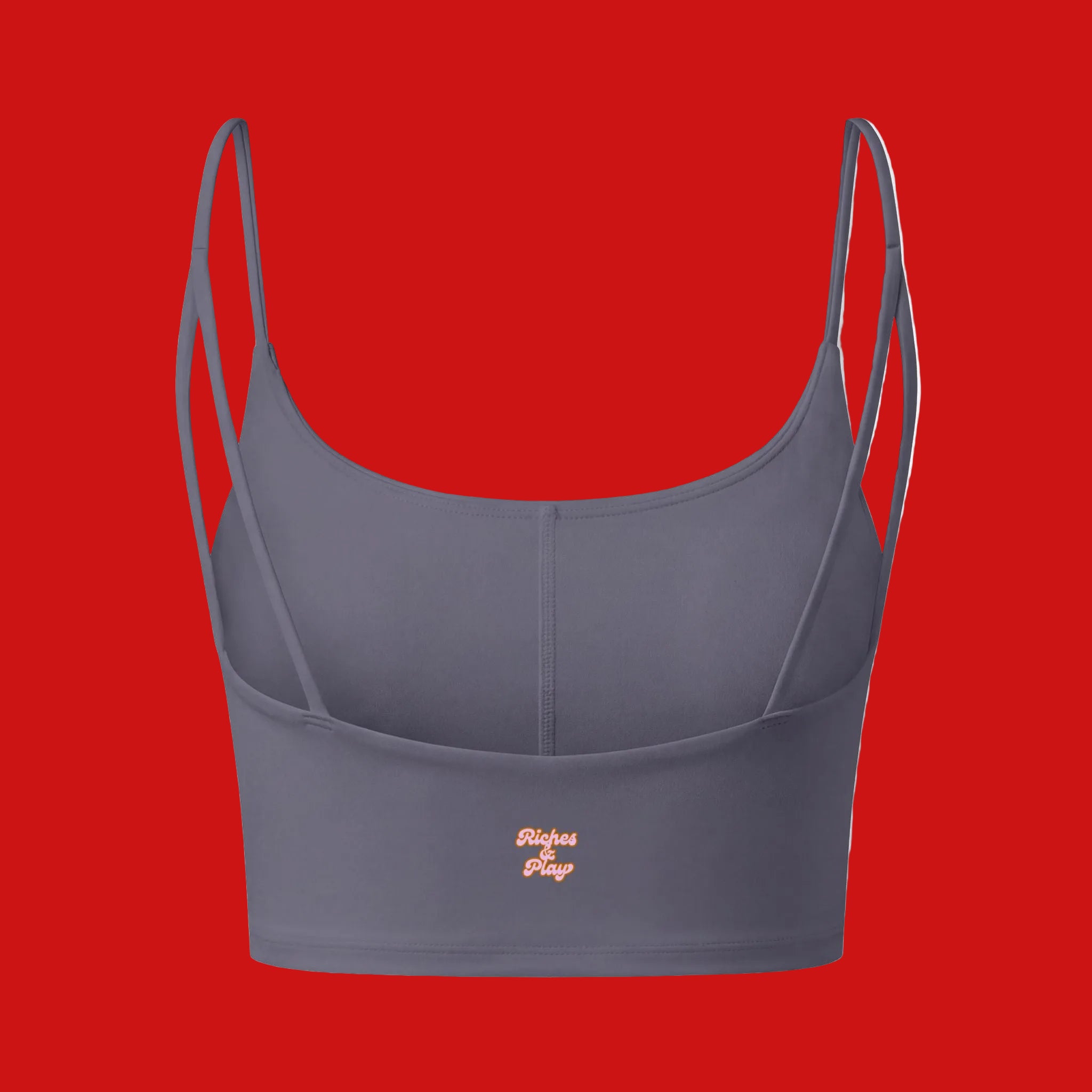 Gray sports bra with a small flag patch on a red background