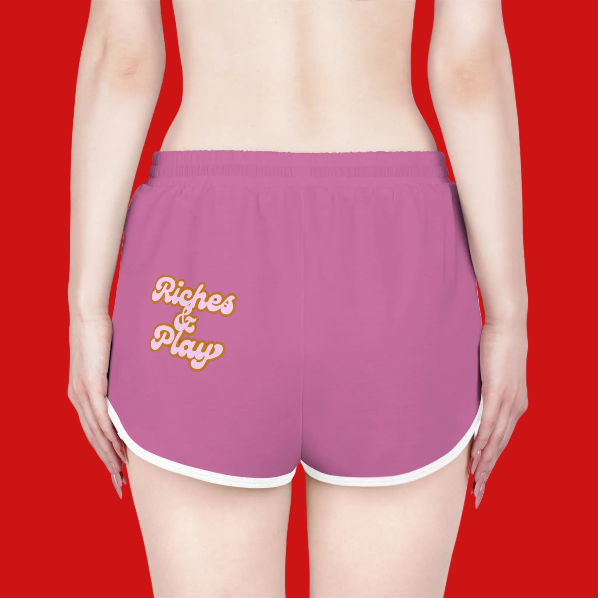 Purple shorts with 'Riches & Play' text on a red background