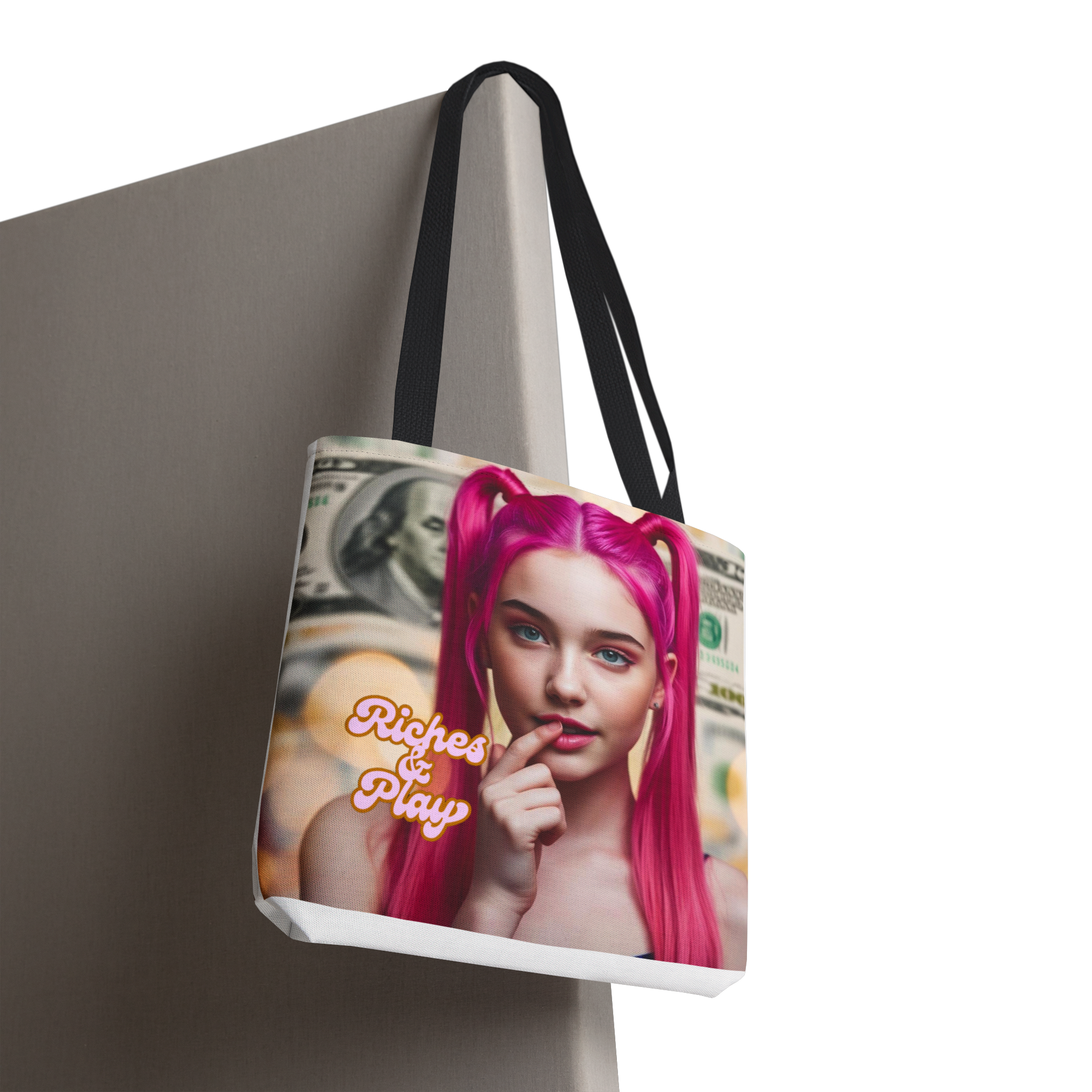 Tote bag with a design of a person with pink hair and text 'Riches & Play' on a neutral background