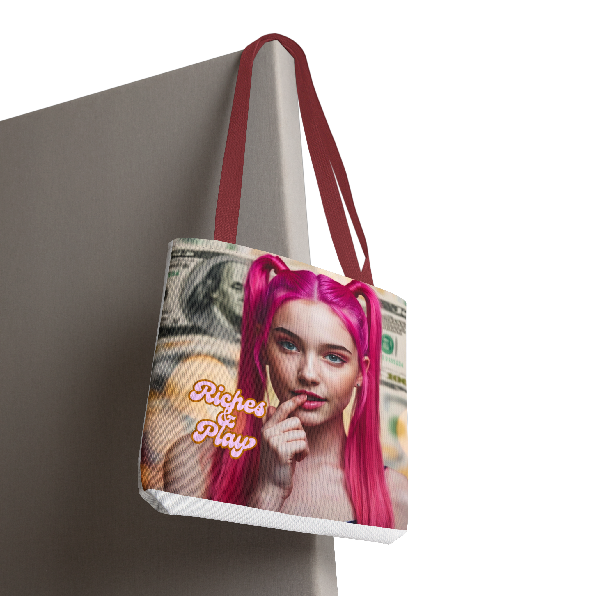 Tote bag with a graphic design of a person with pink hair and text 'Riches & Play' on a neutral background